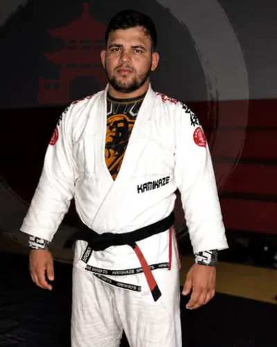 Professor Lucas de kimono branco e faixa preta, no tatame
